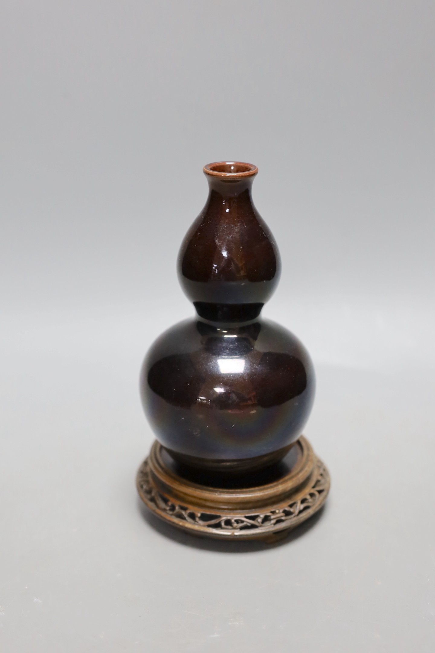 A Chinese brown monochrome double gourd vase (on stand). 19cm tall